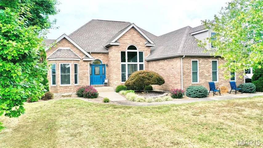 View of front of home featuring a shingled roof, a front lawn, and brick siding