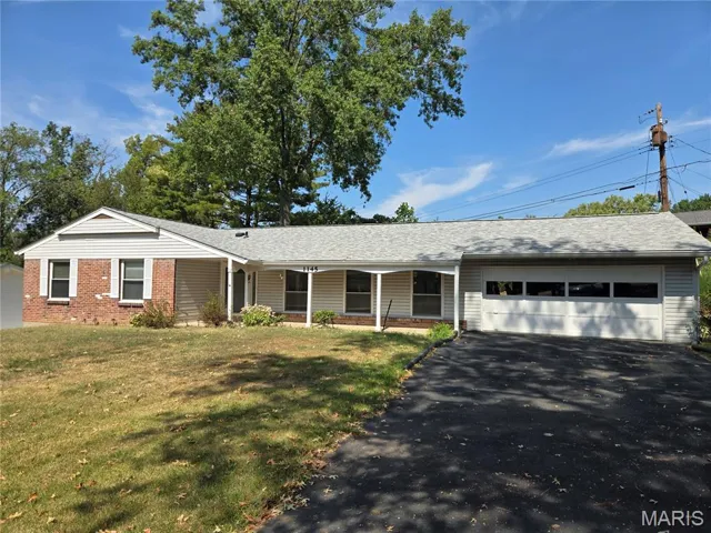 Ranch-style home featuring roof with shingles, an attached garage, a porch, and driveway
