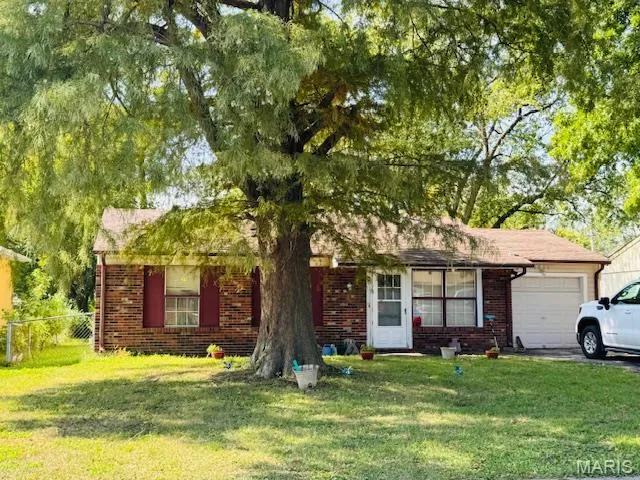 Ranch-style house with brick siding, a garage, and driveway