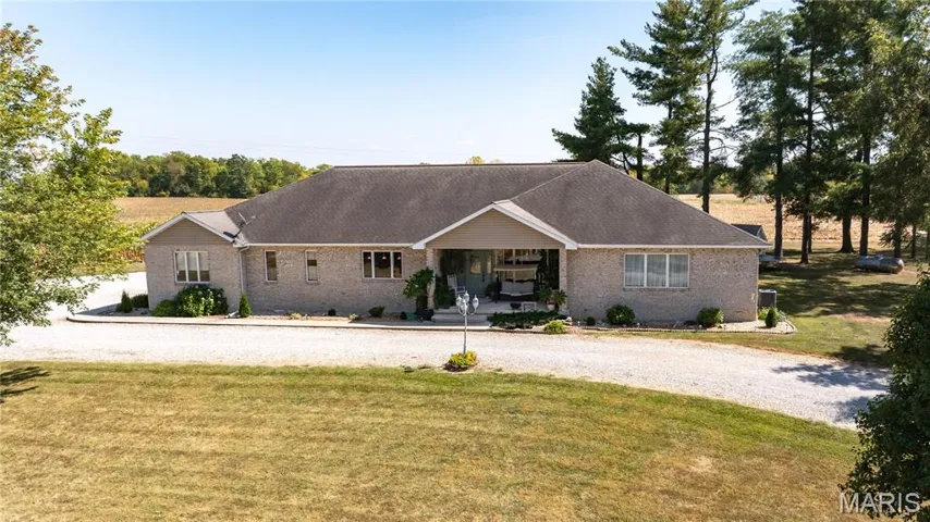 Ranch-style house featuring covered porch, a front lawn, brick siding, and a shingled roof