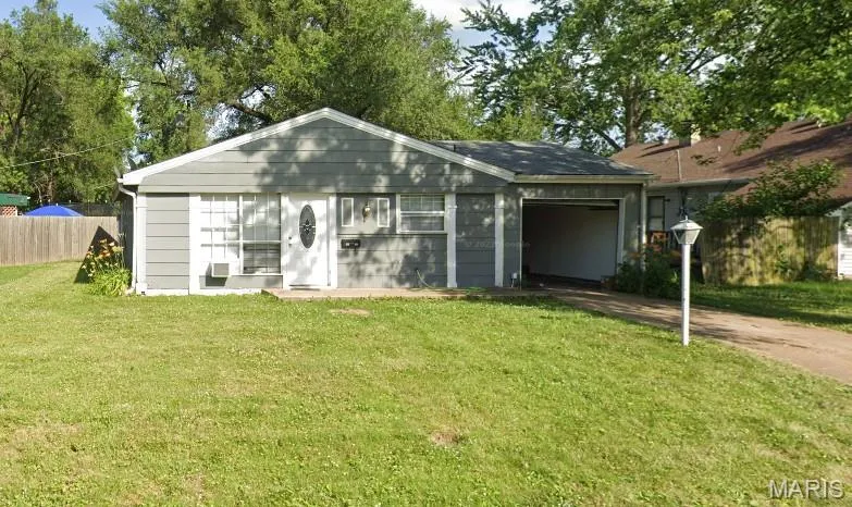 Ranch-style house featuring driveway and an attached garage
