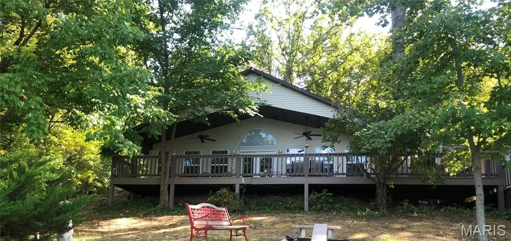 Back of property featuring a deck and ceiling fan