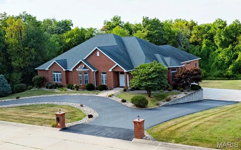 View of front of property featuring a front yard and circle driveway.