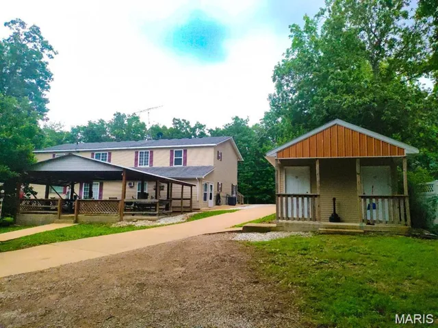 View of front of property with covered porch and an outbuilding