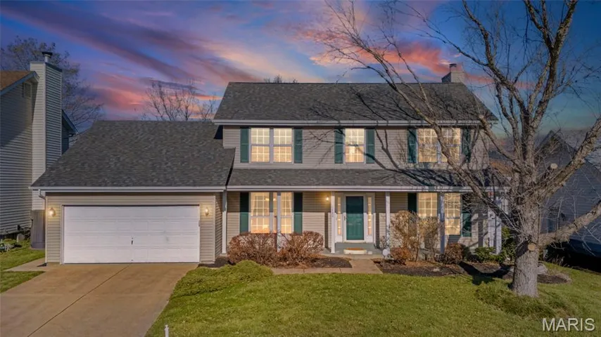 Traditional home featuring covered porch, driveway, a yard, an attached garage, and a shingled roof