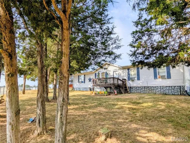 View of grassy yard featuring a wooden deck