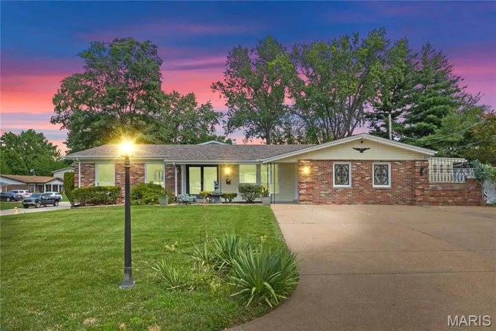Ranch-style house featuring driveway, brick siding, a front yard, and covered porch