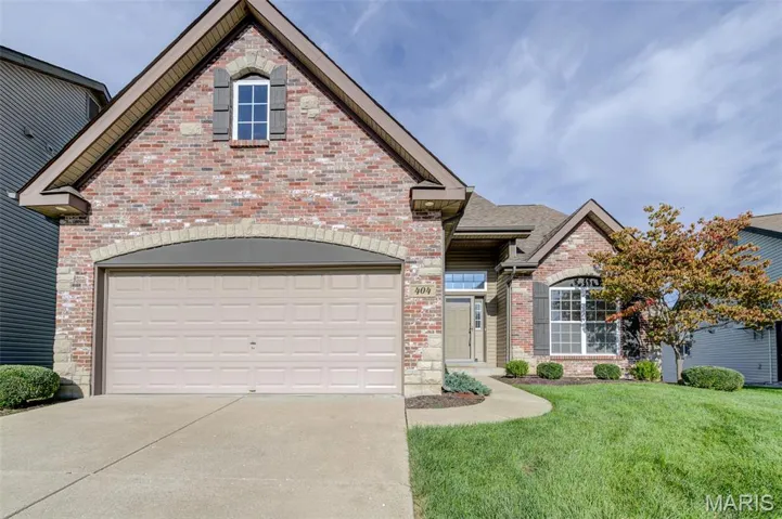 View of front of house with brick siding, concrete driveway, a front yard, a garage, and roof with shingles