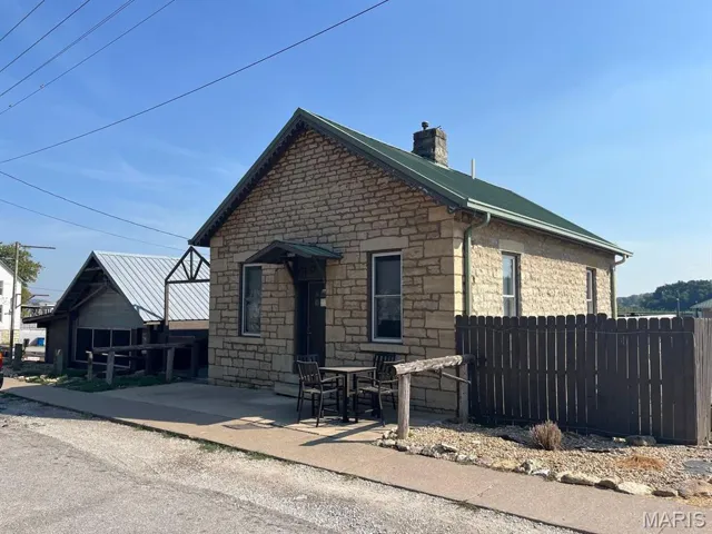 View of side of property with a chimney and stone siding