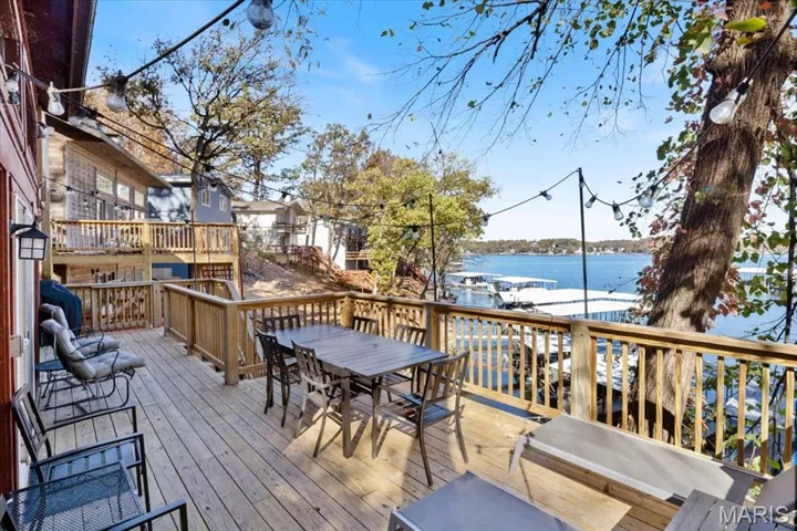 Wooden deck with a water view and outdoor dining space