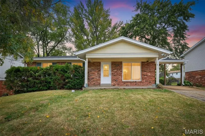 Ranch-style home featuring a front yard, covered porch, and brick siding