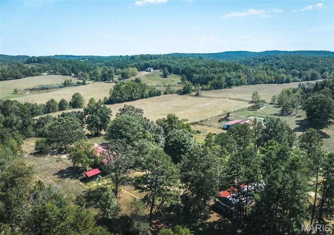 View of property location featuring a heavily wooded area and rural landscape