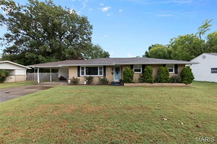 Ranch-style house featuring driveway, brick siding, and a carport
