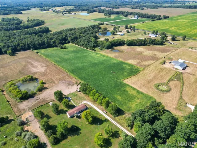 Aerial overview of property's location featuring rural landscape, rows of crops, and a nearby body of water