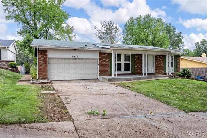 Single story home with brick siding, driveway, a garage, and a porch