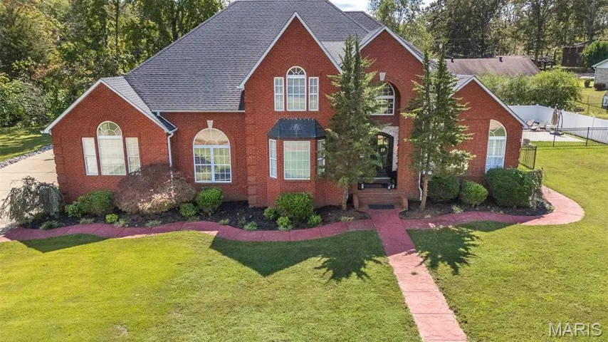 Traditional-style house featuring brick siding and a shingled roof