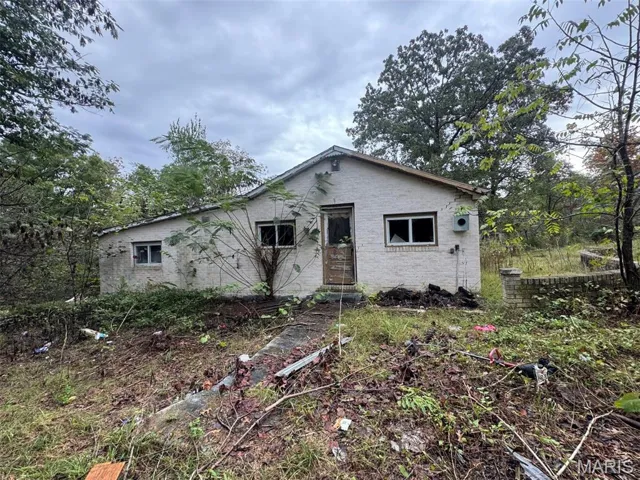 Bungalow featuring brick siding