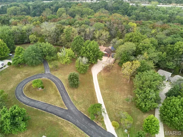 Aerial view of property's location featuring a forest