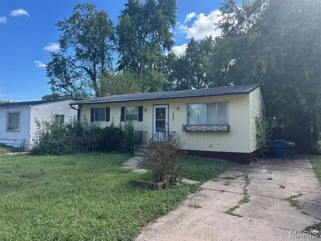 View of front facade with a front yard and driveway