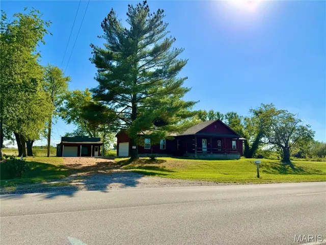 Ranch-style house with a garage, a front yard, driveway, and covered porch