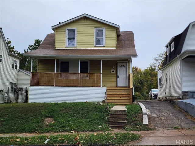 View of front of house with a porch, roof with shingles, and a front yard