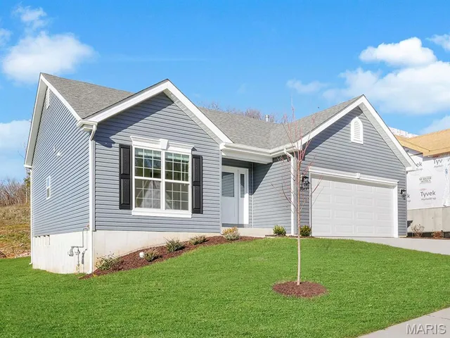 Ranch-style home with a front lawn, driveway, and a shingled roof