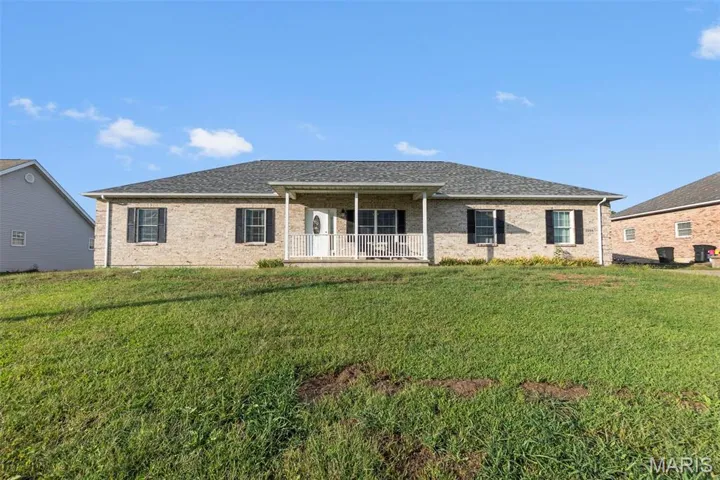 Ranch-style home with brick siding, a front lawn, and a shingled roof