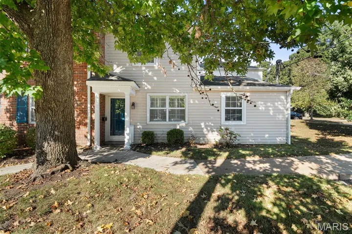 Back of house with a yard and brick siding
