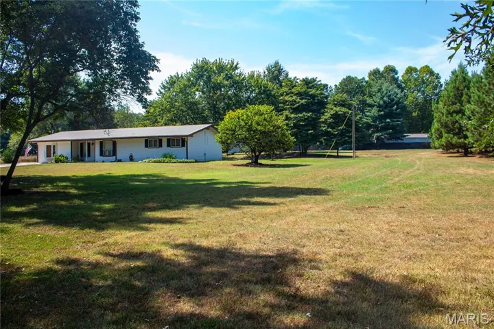 View of green lawn with view of wooded area