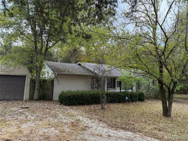 View of front of property featuring a garage and an outdoor structure