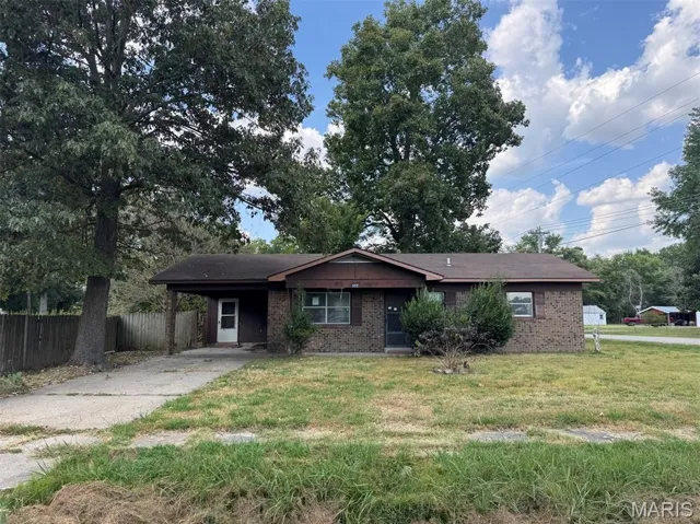 Single story home featuring driveway, an attached carport, and brick siding
