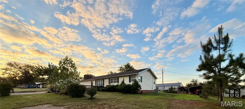 View of front of property featuring a front yard and a chimney