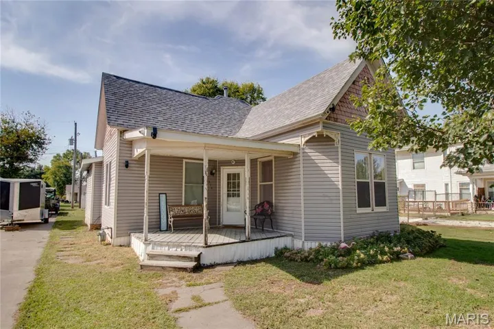 View of front of home with a shingled roof and a front yard