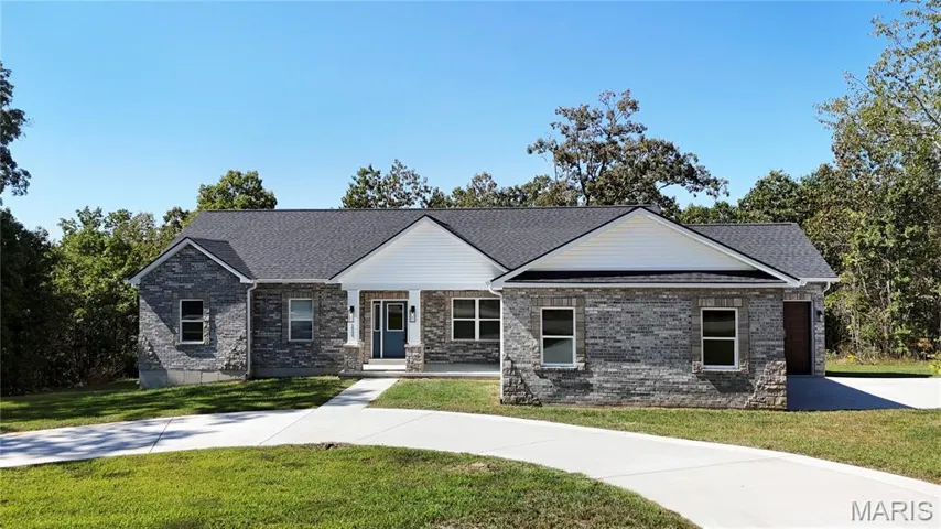 View of front of property featuring covered porch, a front yard, brick siding, and roof with shingles