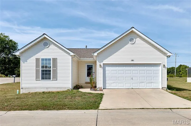 Ranch-style house with driveway, a front yard, and an attached garage