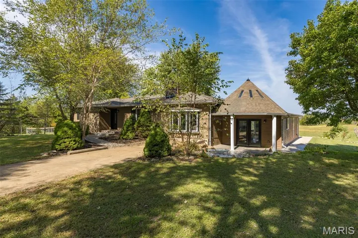 View of front facade with a front lawn, a patio area, and french doors
