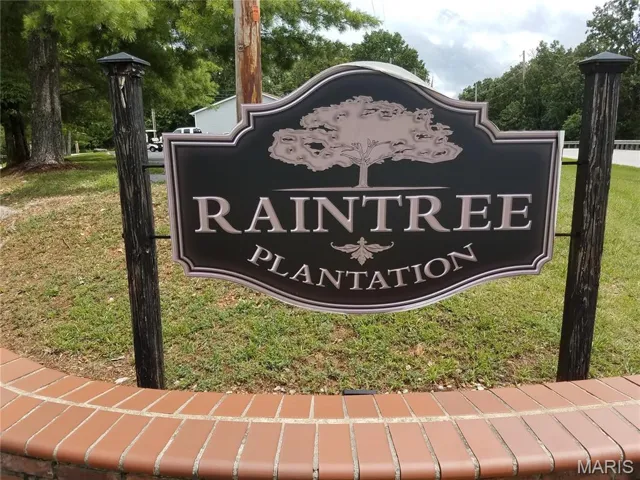 Community / neighborhood sign featuring a yard