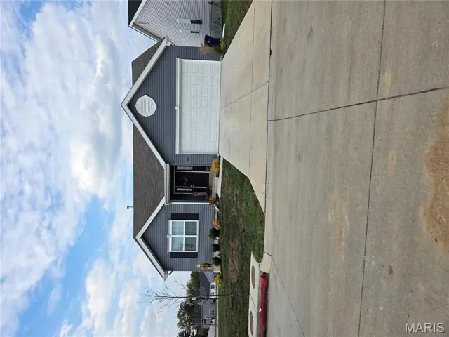 Ranch-style house with a front yard, driveway, and an attached garage