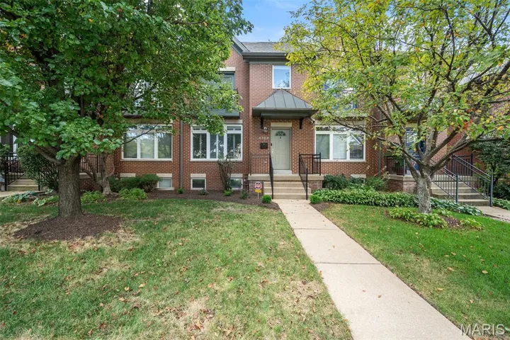 View of front of property featuring brick siding and a front yard