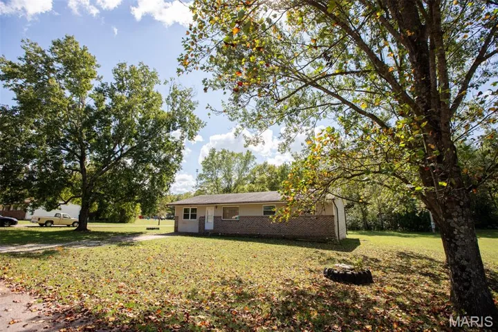 View of front of property featuring a front lawn and brick siding
