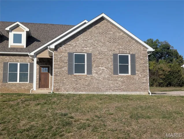 View of front of house with a front yard and brick siding
