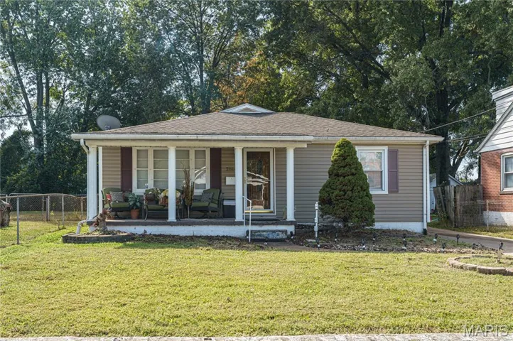 Bungalow featuring a porch, a yard, and view of scattered trees
