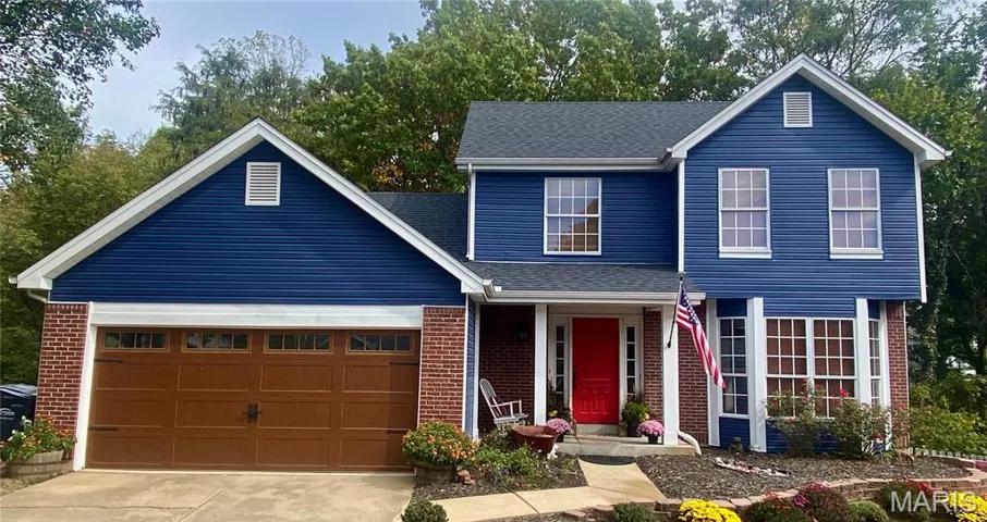 Traditional-style home featuring brick siding, a porch, roof with shingles, an attached garage, and concrete driveway