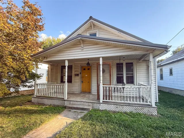 View of front of property with a porch and a front yard