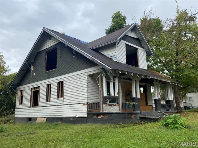 View of side of property featuring a porch and a yard
