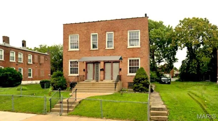 View of front of property featuring a gate, brick siding, and a fenced front yard