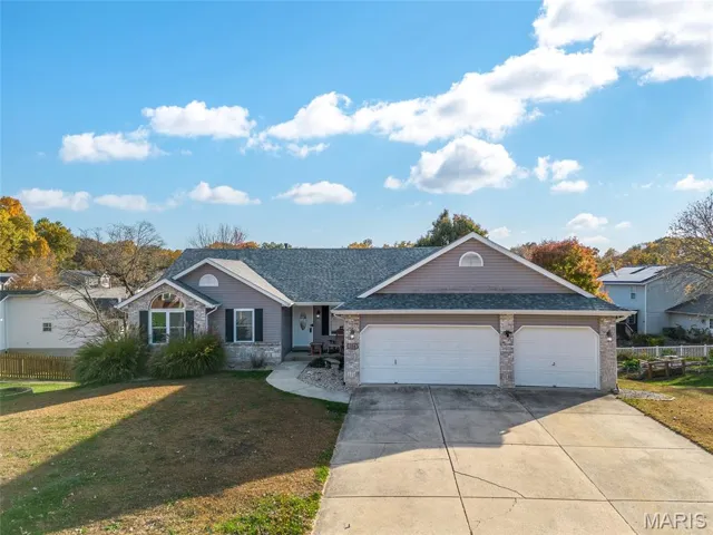 Single story home featuring driveway, an attached garage, roof with shingles, and brick siding