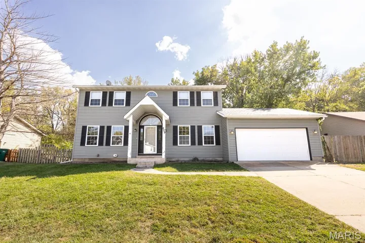 Colonial-style house with driveway and a garage