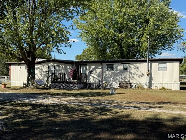 View of front facade featuring a deck and a front lawn