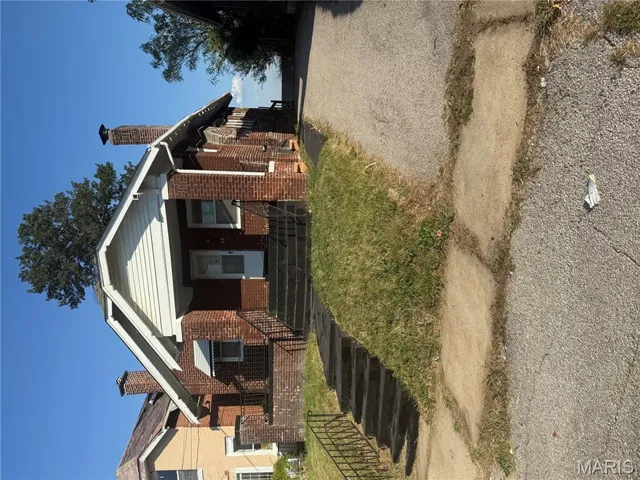 Bungalow with a chimney, brick siding, and a porch